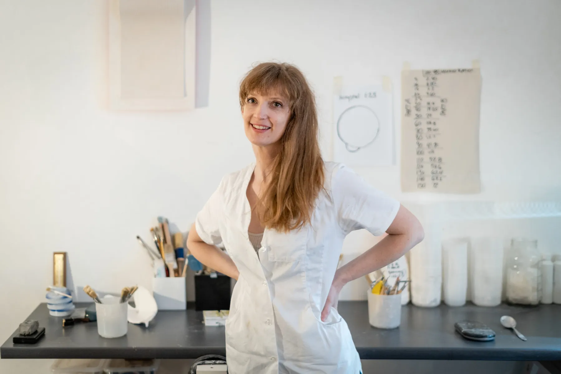 Brooke Meenan lächelnd in ihrem Studio, im weißen Arbeitskittel
